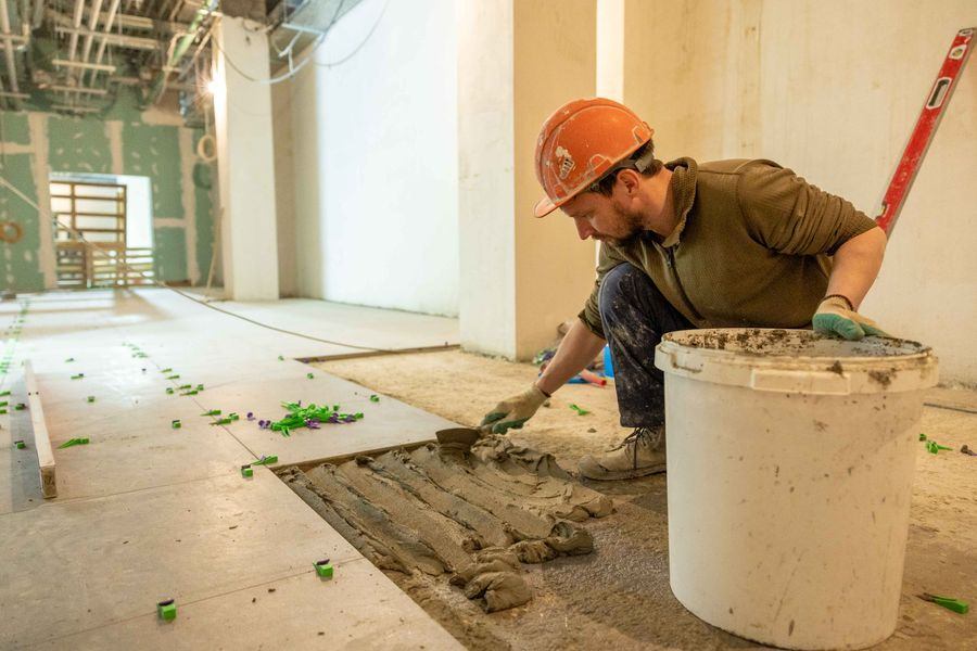 Artisan posant du carrelage sur un chantier